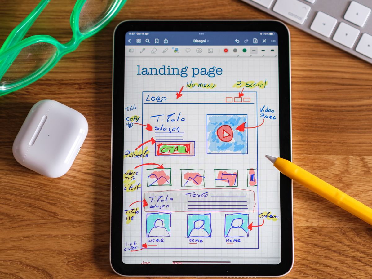 A landing page layout sketched on a tablet and marked up with review notes and arrows
