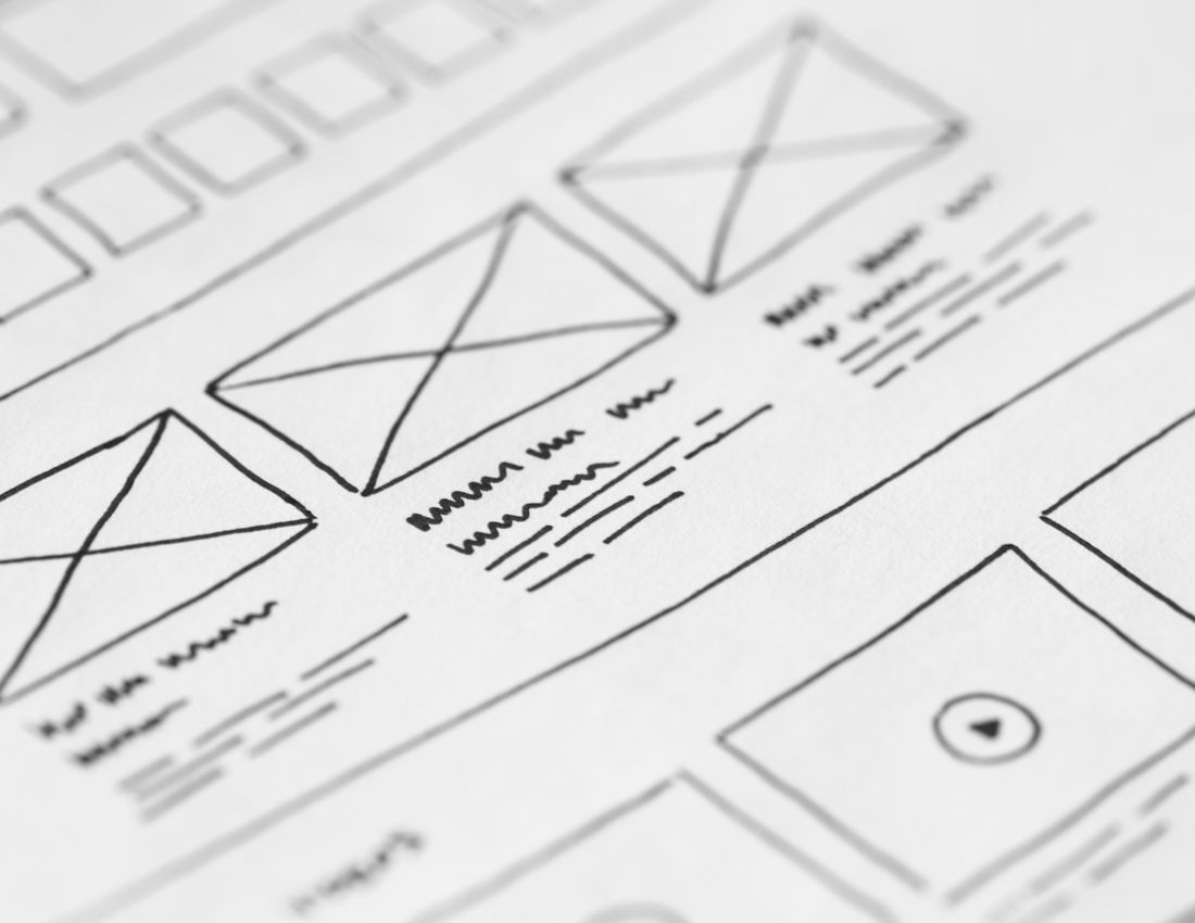 Printed wireframe sheets showing page layouts in black and white